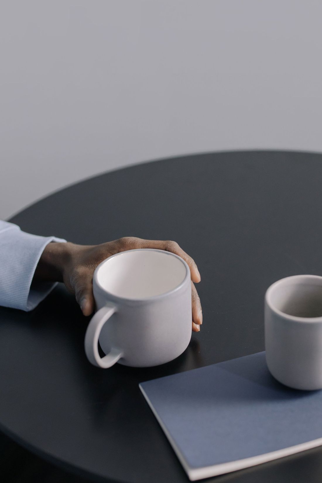 Une main posée sur une tasse, sur une table de rendez-vous
